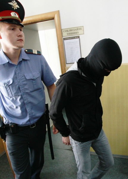 Сотрудник правоохранительных органов конвоирует одного из фигурантов дела о взрыве в аэропорту "Домодедово" Ислама Евлоева