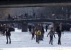 Жители Амстердама прогуливаются по замёрзшему каналу в центре города.