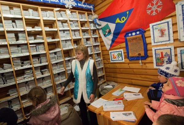 Сотрудница Почты Деда Мороза сортирует письма, пришедшие на имя Деда Мороза