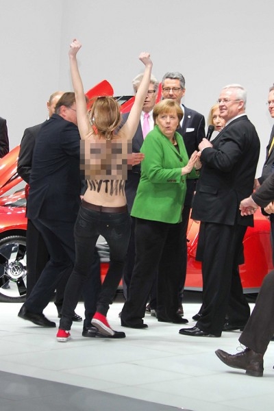 Когда лидеры государства осматривали стенд Volksvagen, активистки начали выкрикивать оскорбительные лозунги. На груди и на спинах участниц акции были написаны оскорбления в адрес президента России