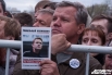 Участник митинга держит  листовку с фотографией оппозиционера Алексея Навального, который проходит по делу о хищениях лесоматериалов.