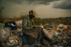 1-е место в категории «Проблемы современности. Одиночная фотография». Найроби, Кения, 3 апреля 2012 года. Женщина, работающая сборщицей мусора на свалке, с удовольствием листает книги, которые иногда попадаются ей среди мусора. 