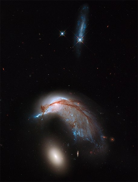 Столкновение галактик NGC 2936 и NGC 2937. Фотография сделана благодаря совмещению видимого и инфракрасного излучений камерой WFC3 на борту телескопа «Хаббл».