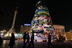 На Майдане Незалежности протестующие заклеили своими плакатами и листовками каркас новогодней ёлки, которую к моменту начала протестов собрать до конца власти не успели.