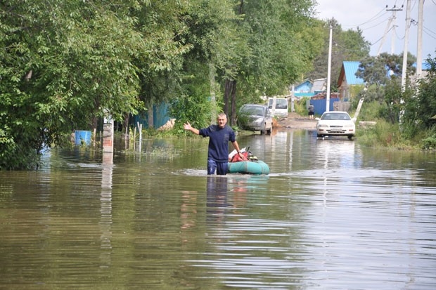 Жители подтопленных районов города передвигаются на лодках.