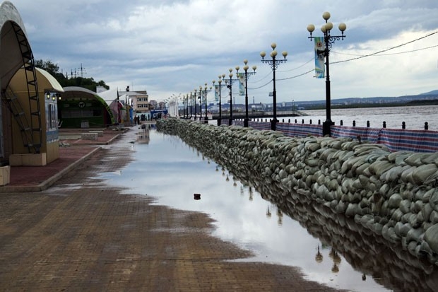 Вода пока не поднялась за мешками со стороны набережной, но видно, что заграждение пропускает даже то количество воды, которое переливается из русла.