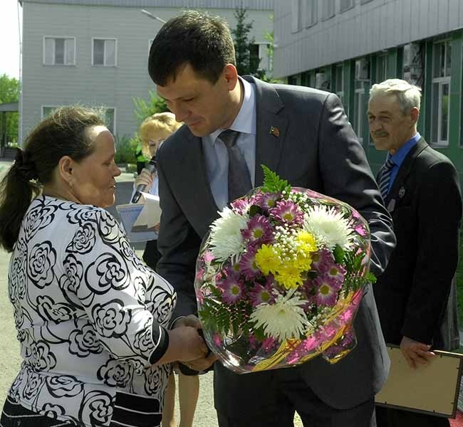 Людмила Яровикова принимает букет и поздравления от Владимира Шевченко, директора Кедровского разреза