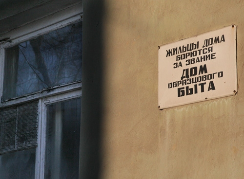Как видим, жильцы дома не могут прекратить соревнование за быт, пока их прославляет нетленная табличка.
