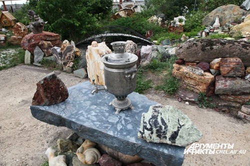 Для гостей накрыт каменный стол с самоваром.