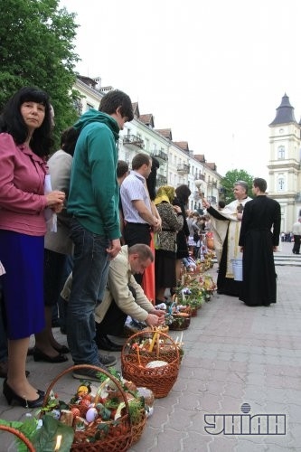 Священник освящает пасхальные корзины накануне празднования Светлого Христова Воскресения возле Архикатедрального собора Воскресения УГКЦ в Ивано-Франковске
