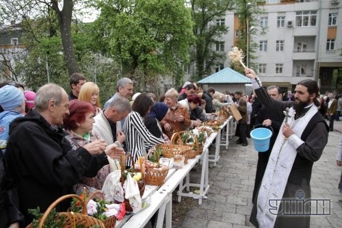 Священнослужитель освящает пасхальные корзины накануне празднования Воскресения Христово во Львове