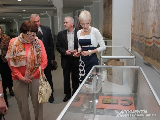 Экскурсовод рассказывает первым посетителям об экспонатах выставки «Русь православная».