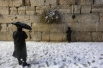 Выпавший накануне в Израиле снег стал для местных жителей полной неожиданностью – подобная погода здесь считается аномалией. Впрочем, это не остановило желающих подойти к Стене плача в Иерусалиме.
