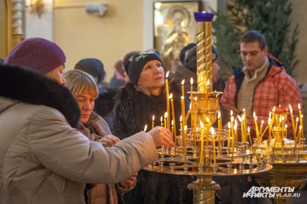 Прихожане ставят свечи за здравие родных.