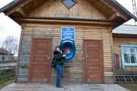 Жительница села Нарым Парабельского района Томской области звонит по телефону-автомату у сельского отделения почтовой связи.