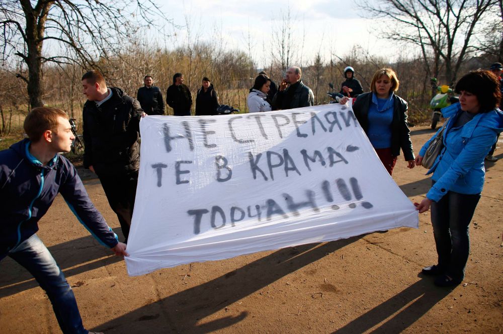 Они держали в руках плакаты, в то время как на территории аэропорта оставались несколько десятков военных из различных подразделений.