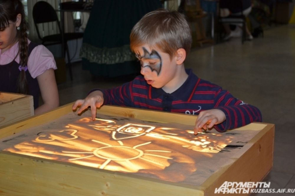 Те, кто ещё не умеет писать, могли порисовать, но не на обычной бумаге. Дети с большим удовольствием учились создавать картины на песке.