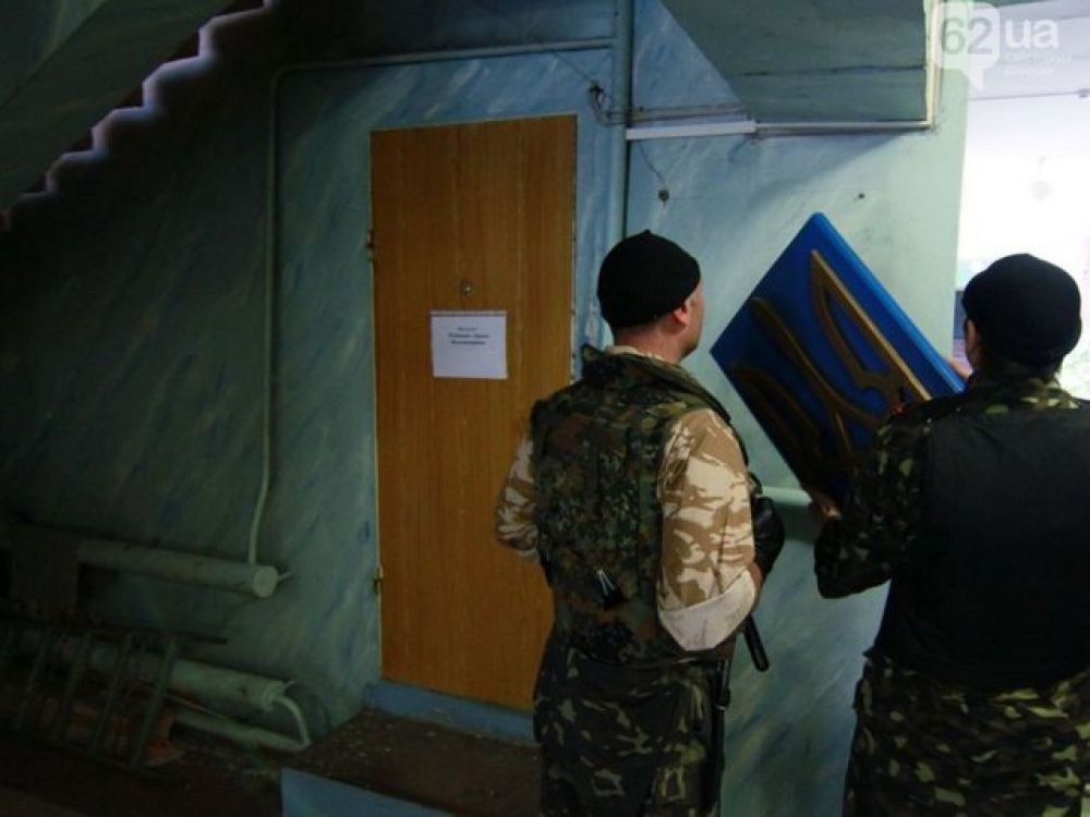 Сепаратисты в Донецке снимают в избирательном штабе герб Украины