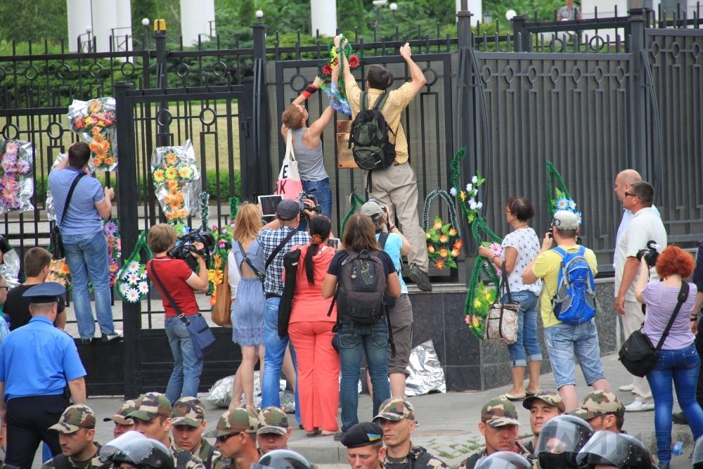 Митингующие пытаются повесить траурные венки на забор генконсульства