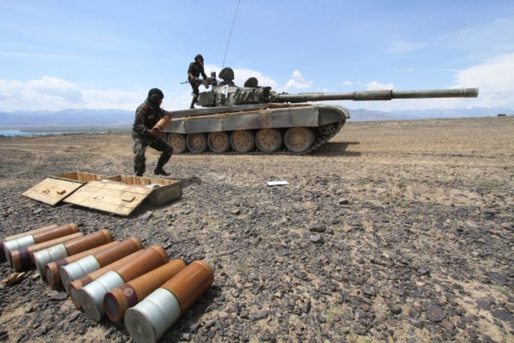 Экипаж танка загружает боеприпасы во время тренировки.