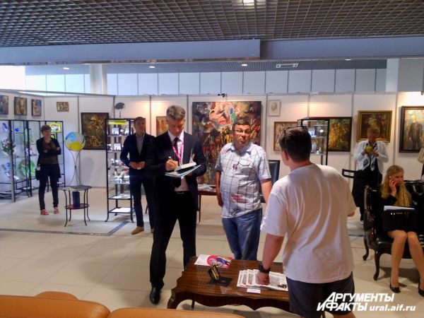 Глава Екатеринбурга Евгений Ройзман на выставке художника Миши Брусиловского. Подписывает читателю свою новую книгу.