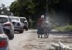 Женщина везет велосипед недалеко от блокпоста