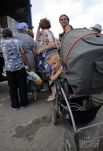 В длинной очереди есть и мамы с малышами