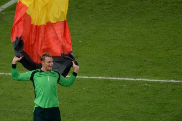 Вратарь сборной Германии Мануэль Нойер в немецким флагом празднует победу на чемпионате мира по футболу–2014