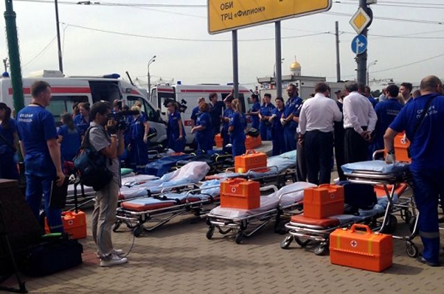 Работники «Скорой помощи» и МЧС готовят носилки для перевозки пострадавших.