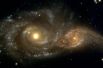 Столкновение галактик NGC 2207 и IC 2163 в созвездии Большого Пса, около 80 миллионов световых лет от Земли. В данный момент эти галактики лишь на ранней стадии слияния и пока функционируют как независимые друг от друга, но, согласно учёным, через миллиард лет они сольются в одну эллиптическую галактику.