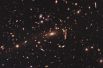 Блок из 25 скоплений галактик MACS 1206. Скопление образует целый кластер гравитационных линз – сила притяжения в этом месте настолько высока, что способна преломлять свет так сильно, что на снимках остаётся по нескольку изображений одного и того же объекта. Одним из самых сильных источников гравитации здесь является галактика RX J1347.5-1145. 