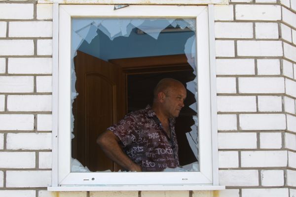 Житель Донецка осматривает здание, где располагалось его кафе, после боя между украинской армией и ополченцами 2 августа 2014 года.