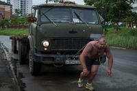 Иван Савкин тянет грузовик.