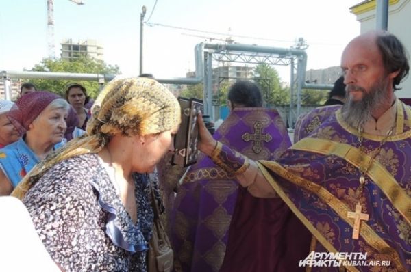 Отец Евгений дает целовать священное Евангелие.