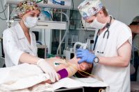 Анестезиолог-реаниматолог контролирует состояние пациента на новом оборудовании.