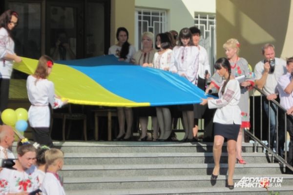 Старшеклассники выносят государственный флаг Украины