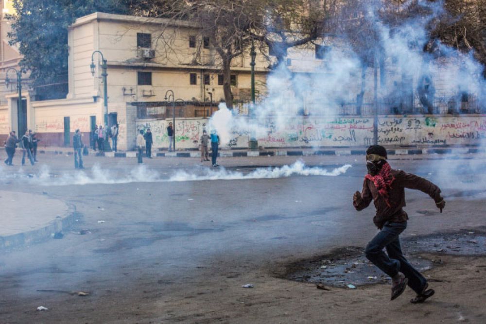Участник акций протеста во время столкновений с полицией возле площади Тахрир в Каире.