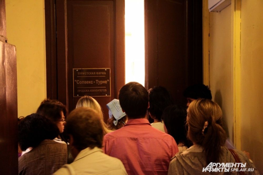 Двери турфирмы пропускают маленькие группы людей, желающих забрать документы.