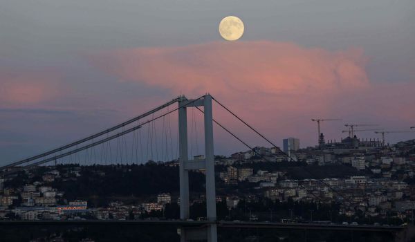 Суперлуние над Босфорским мостом в Стамбуле, Турция.