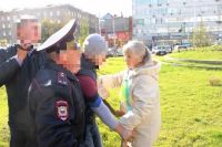 «Православный активист» разрывает антивоенный плакат, который держала женщина почтенных лет.