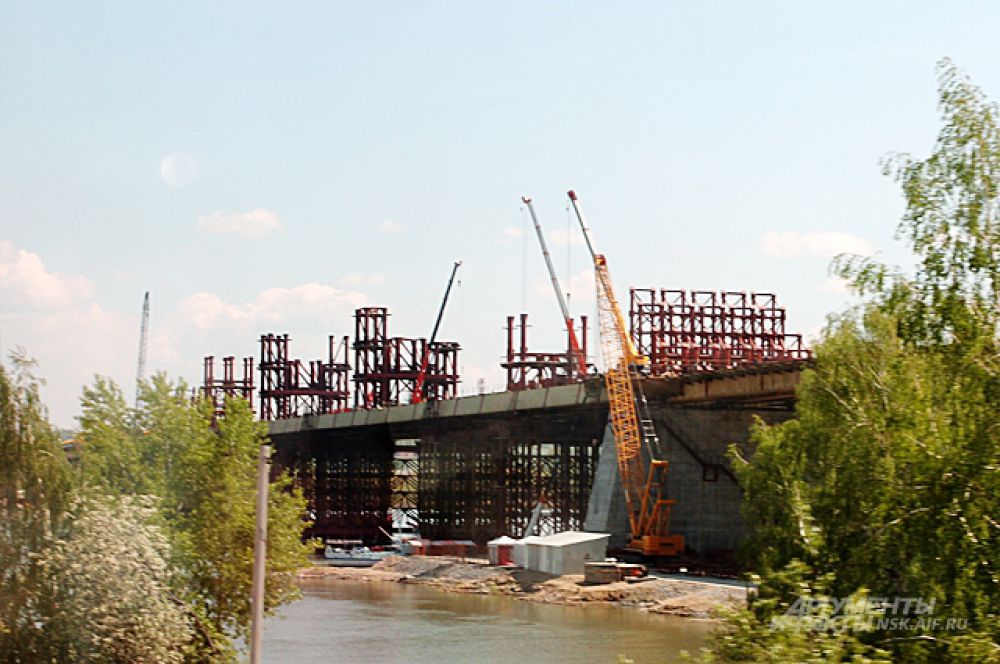 Спустя год после первых фотографий этой ленты - в июне 2013-го - у моста уже появилась балочная конструкция, по которой в будущем поедут автомобили.