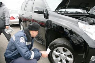 Сотрудник ГАИ проверяет автомобиль
