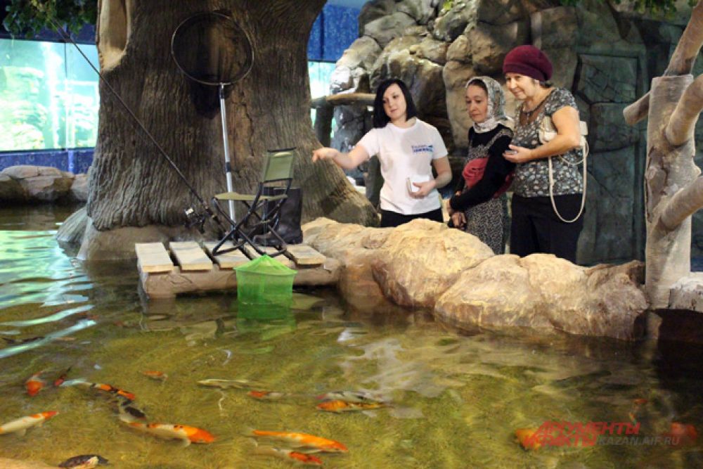 Экскурсовод объясняет посетителям особенности здешних рыб.