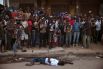 Толпа прохожих вокруг тела человека, предположительно умершего от лихорадки Эбола. Город Койду в Сьерра-Леоне.