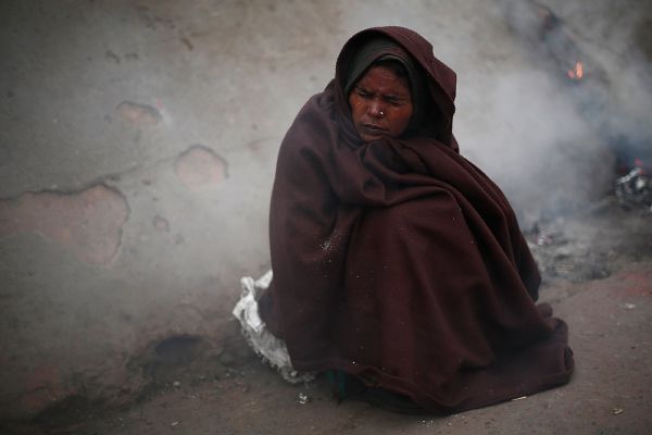 Женщина в лоскутном одеяле в старам квартале Дели.