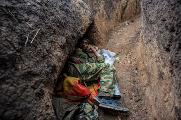 Ополченец отдыхает в траншее на передовой позиции в поселке Семеновка.