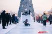 Так иркутская ель выглядит днем, когда народ катается на ледовых горках, устроенных на площади.