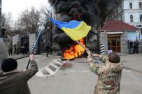 Участники акции протеста бойцов батальона «Айдар» и их сторонников жгут автомобильные покрышки у здания министерства обороны Украины в Киеве.