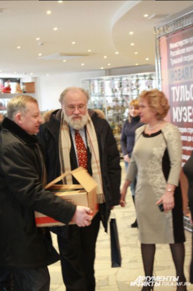 Секретарь облизбиркома Николай Климов помогает Владимиру Чурову нести подарки
