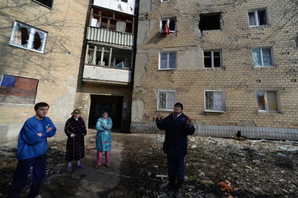 Жители Донецка во дворе дома, пострадавшего в результате обстрела города.